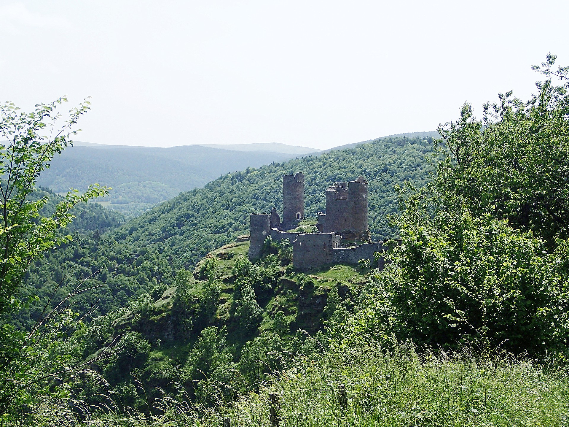 L'étonnant château du Tournel dans son écrin de verdure.