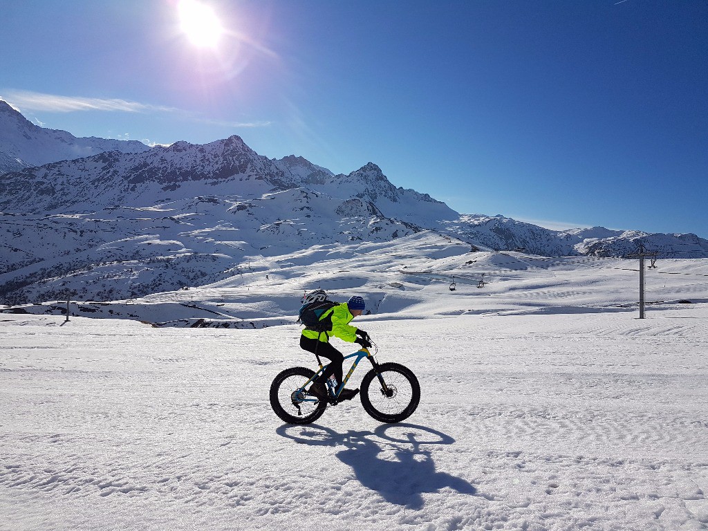 Alban grimpe sur la piste de ski de couleur bleu. 